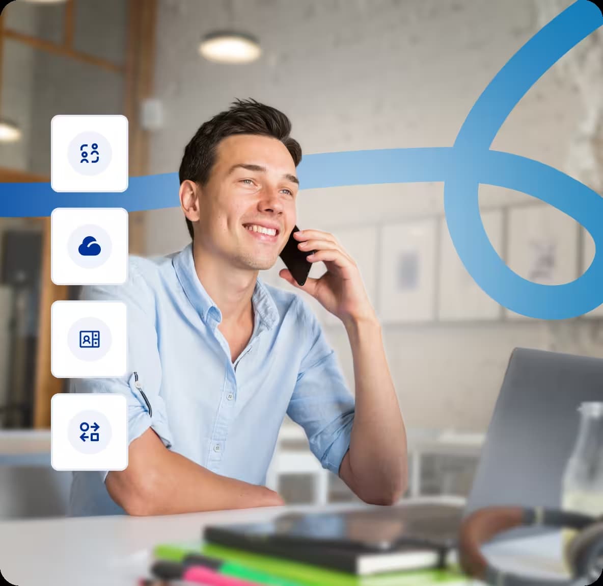 smiling young man talking on a mobile phone while working at a desk with a laptop and business communication icons on the left side