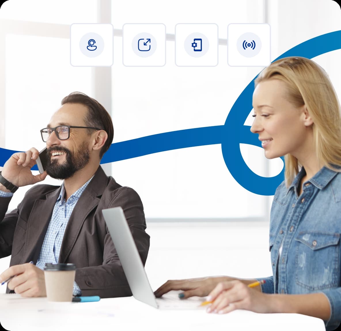 Business team collaborating in office with one person on a phone call and another working on laptop