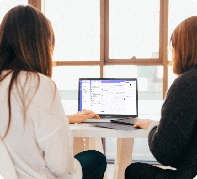 Professional women discussing while looking at screen